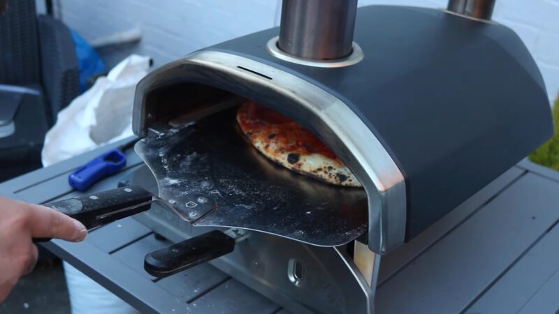 Sliding pizza into the oven using a pizza peel