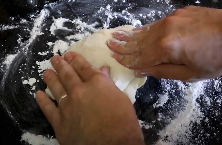 Flour dusted surface, hands working the dough