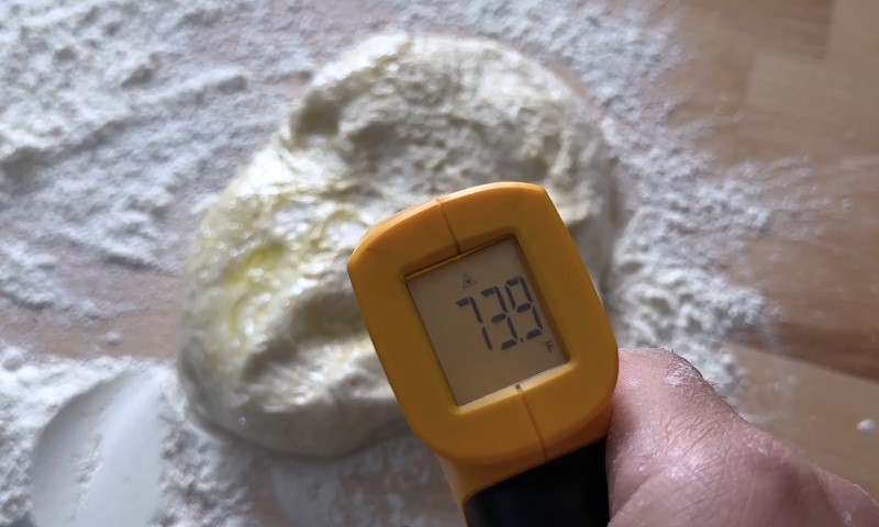Person checking temperature of pizza dough