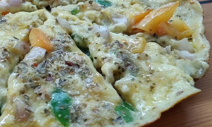 A pizza topped with halloumi cheese and a variety of fresh vegetables