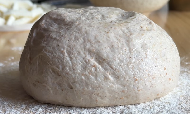 A ball of dough resting on a bed of flour